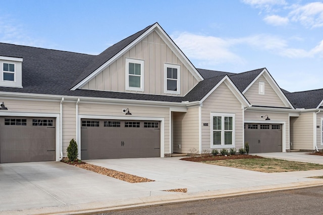 view of property with board and batten siding, a shingled roof, and concrete driveway