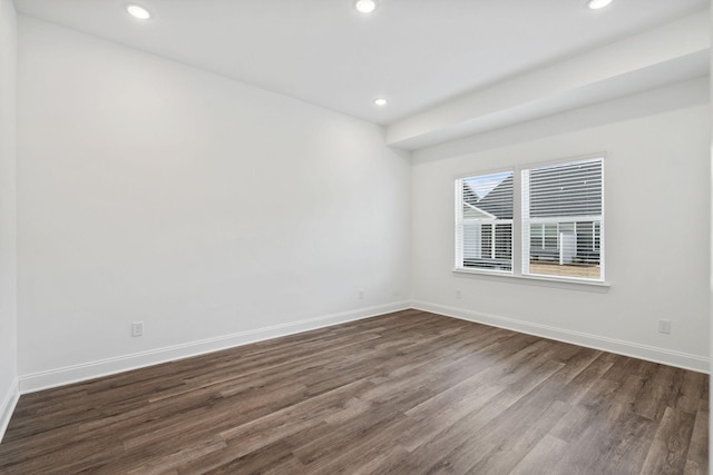 empty room featuring recessed lighting, baseboards, and dark wood-style flooring