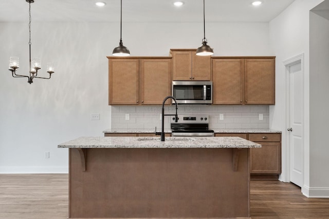 kitchen with baseboards, appliances with stainless steel finishes, a sink, and dark wood-style floors