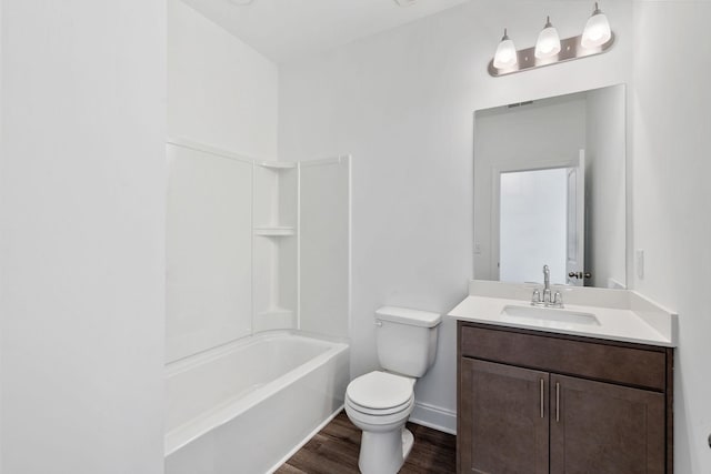 bathroom featuring toilet, bathtub / shower combination, baseboards, wood finished floors, and vanity