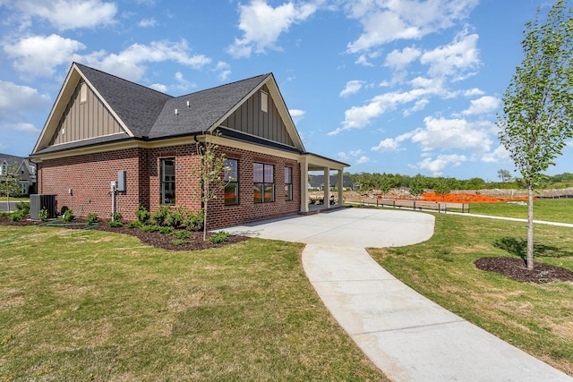 view of property exterior with central AC unit, brick siding, a patio area, a lawn, and board and batten siding
