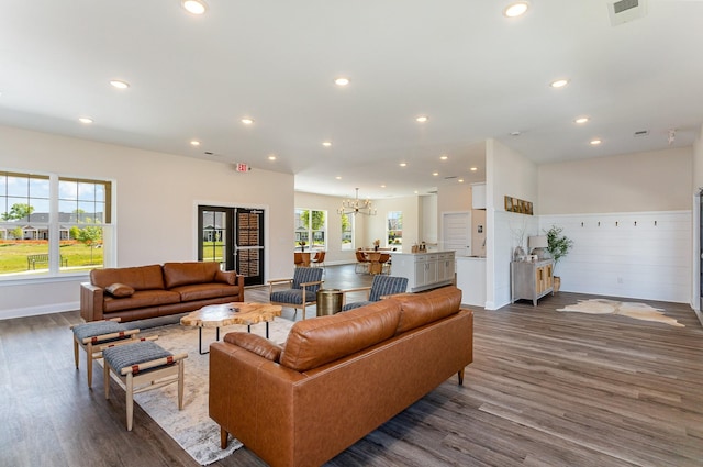 living room featuring dark wood-style flooring, baseboards, visible vents, recessed lighting, and a chandelier