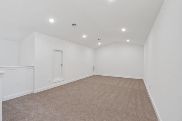 unfurnished room featuring recessed lighting, vaulted ceiling, visible vents, light carpet, and baseboards
