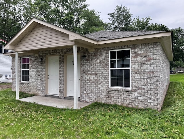 513 5th St, Lawrenceburg, TN 38464 - view of front of property featuring a front yard, brick siding, and roof with shingles