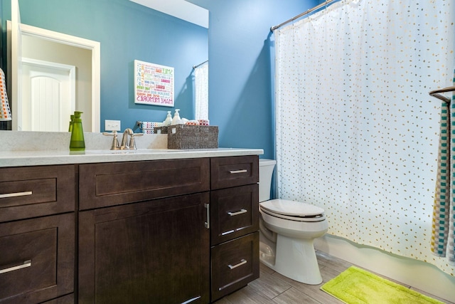 bathroom featuring wood finished floors, vanity, a shower with shower curtain, and toilet