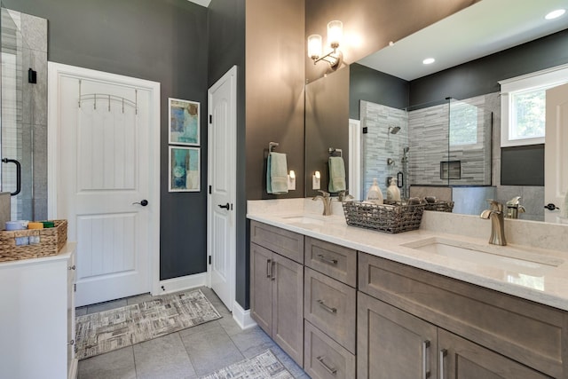 bathroom with double vanity, tile patterned flooring, a stall shower, and a sink