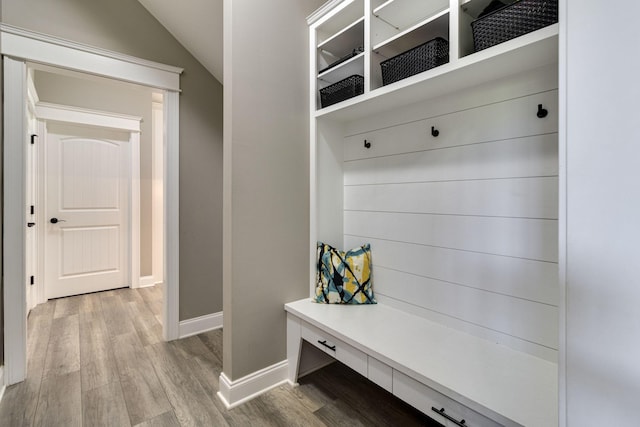 mudroom with wood finished floors, lofted ceiling, and baseboards