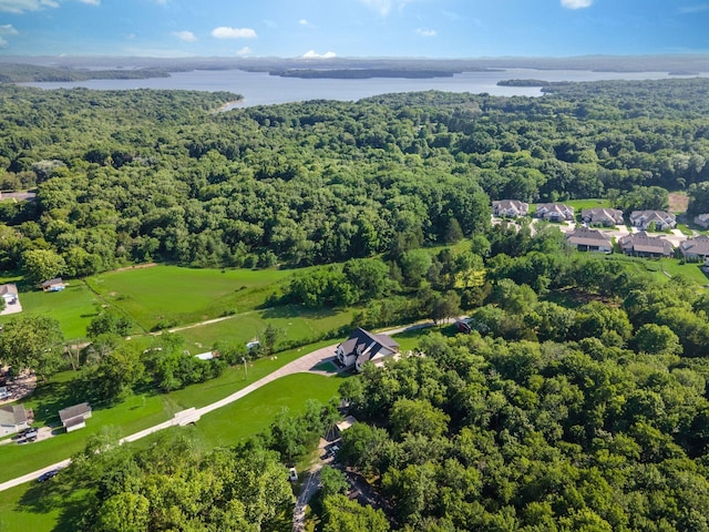drone / aerial view featuring a wooded view and a water view