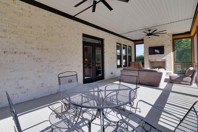 view of patio / terrace with an outdoor living space with a fireplace, a ceiling fan, french doors, and outdoor dining area