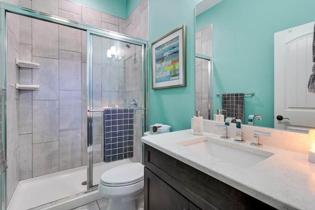 bathroom with tile patterned flooring, vanity, toilet, and a stall shower