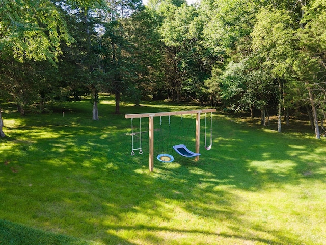 view of property's community featuring playground community and a yard