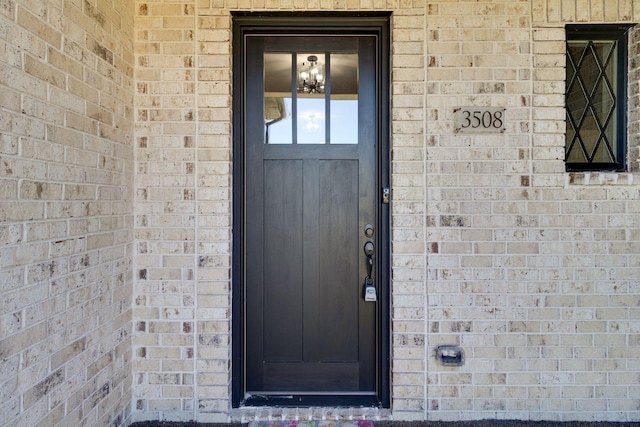view of exterior entry with brick siding