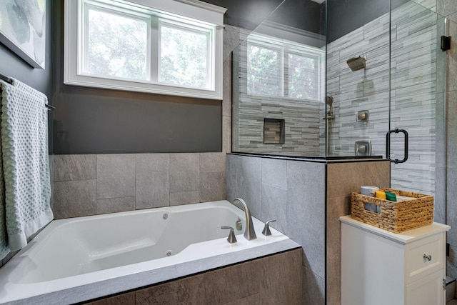full bath with a whirlpool tub, a shower stall, and tile walls
