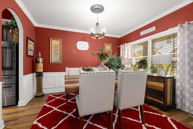 5000 Moretto Ct, Spring Hill, TN 37174 - dining room featuring crown molding, arched walkways, wainscoting, wood finished floors, and an inviting chandelier