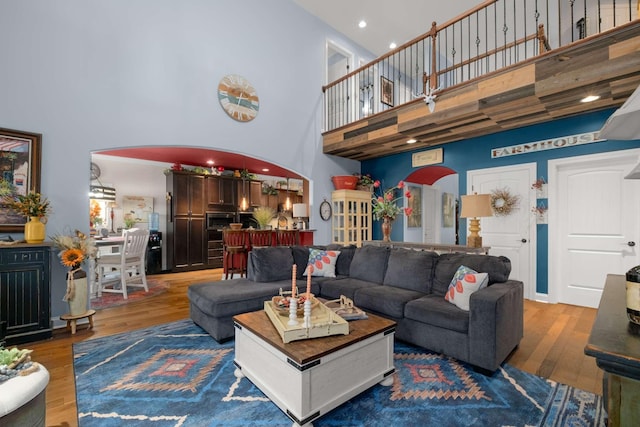 5000 Moretto Ct, Spring Hill, TN 37174 - living room featuring arched walkways, recessed lighting, wood finished floors, and a towering ceiling