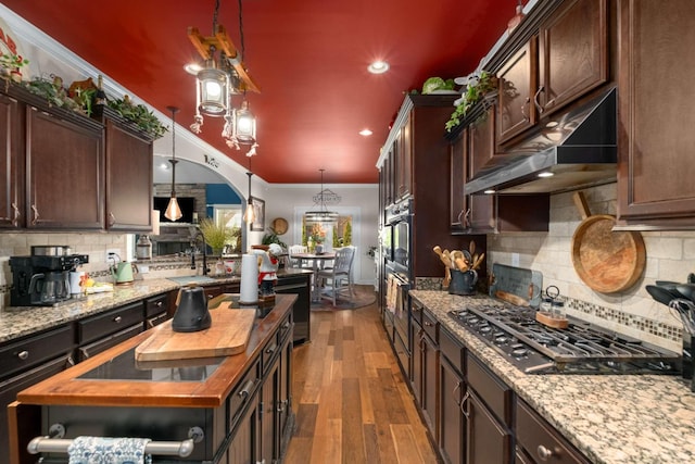 5000 Moretto Ct, Spring Hill, TN 37174 - kitchen featuring wood counters, under cabinet range hood, dark brown cabinets, and black gas cooktop
