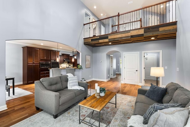 5000 Moretto Ct, Spring Hill, TN 37174 - living area with arched walkways, a towering ceiling, and light wood-style floors