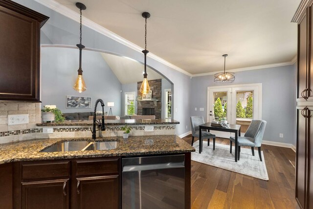 5000 Moretto Ct, Spring Hill, TN 37174 - kitchen with stainless steel dishwasher, arched walkways, dark brown cabinetry, plenty of natural light, and ornamental molding