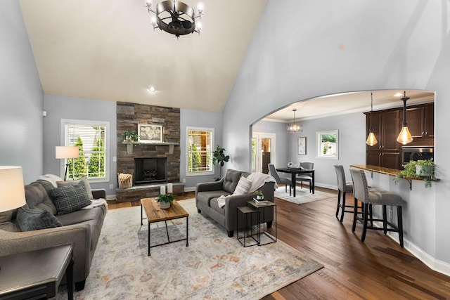 5000 Moretto Ct, Spring Hill, TN 37174 - living room featuring arched walkways, a chandelier, dark wood-type flooring, high vaulted ceiling, and a fireplace