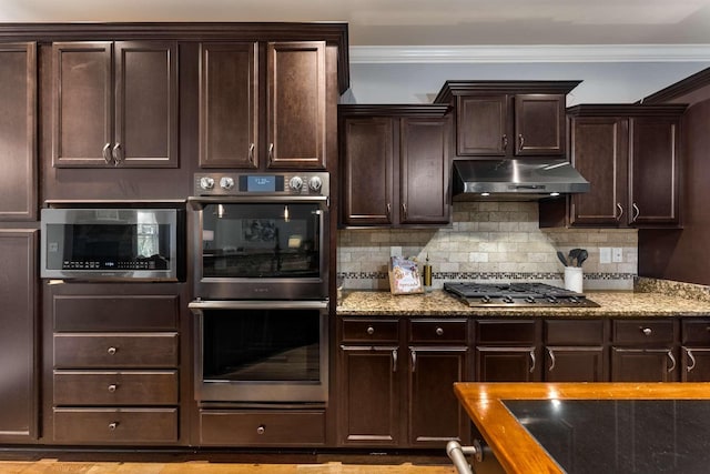 5000 Moretto Ct, Spring Hill, TN 37174 - kitchen featuring under cabinet range hood, stainless steel appliances, crown molding, light stone countertops, and dark brown cabinets