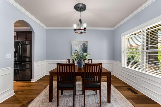 5000 Moretto Ct, Spring Hill, TN 37174 - dining room featuring dark wood-style floors, a chandelier, ornamental molding, arched walkways, and a wainscoted wall
