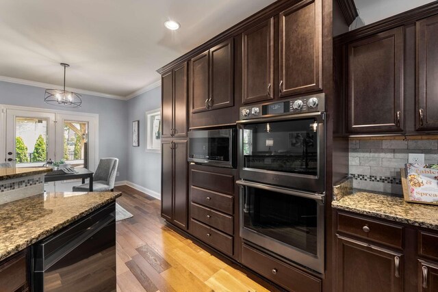 5000 Moretto Ct, Spring Hill, TN 37174 - kitchen with double oven, stainless steel microwave, light stone countertops, backsplash, and crown molding