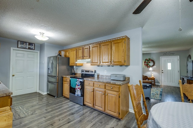 1496 Wade Brown Rd, Lewisburg, TN 37091 - kitchen with under cabinet range hood, stainless steel appliances, wood finished floors, and light countertops