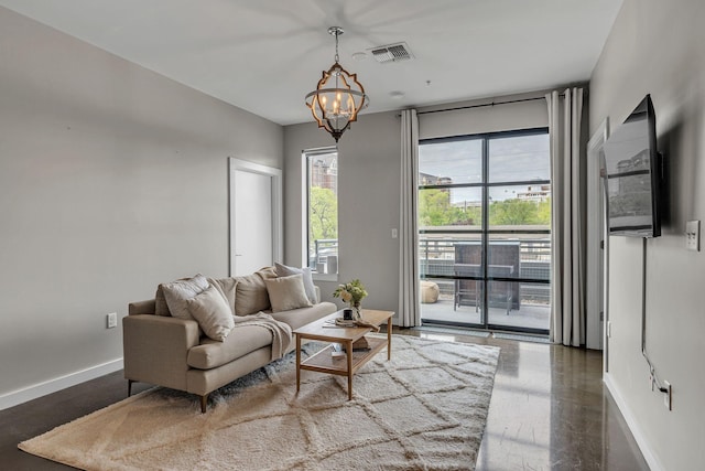 1900 12th Ave S Unit 219, Nashville, TN 37203 - living room featuring visible vents, baseboards, and an inviting chandelier