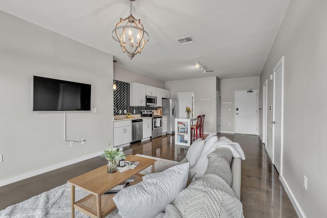 1900 12th Ave S Unit 219, Nashville, TN 37203 - living area featuring concrete flooring, an inviting chandelier, visible vents, and baseboards