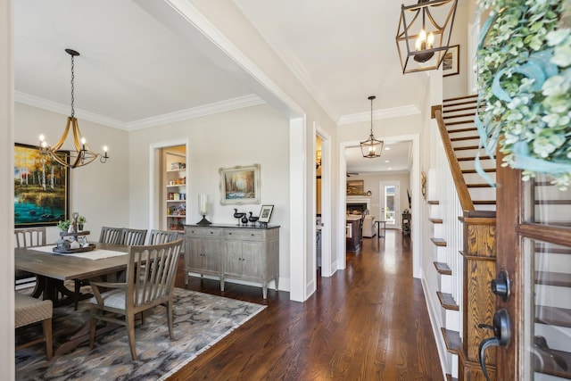dining room featuring crown molding, an inviting chandelier, stairway, and dark wood finished floors