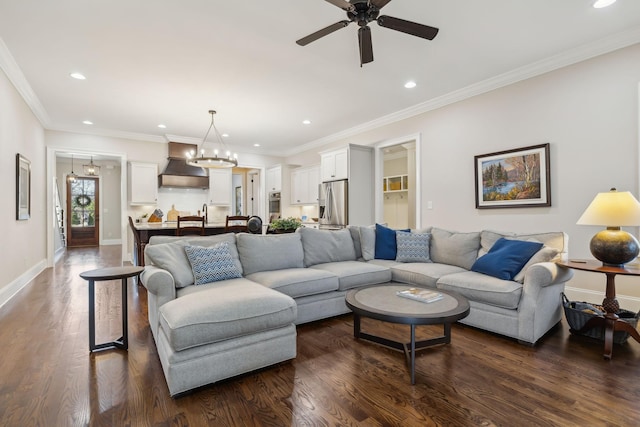 living room with ornamental molding, dark wood-style flooring, ceiling fan with notable chandelier, and recessed lighting
