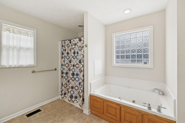 bathroom featuring curtained shower, visible vents, a garden tub, and baseboards