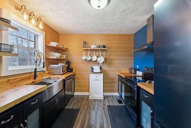 kitchen with wood counters, light wood-type flooring, a textured ceiling, and stainless steel appliances