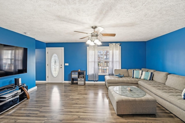 living area featuring wood finished floors, a textured ceiling, baseboards, and ceiling fan