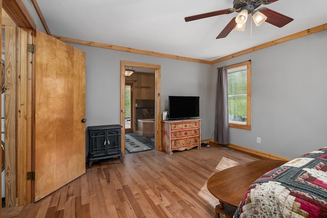237 Cooper Ln, Smithville, TN 37166 - bedroom featuring light wood-type flooring, ceiling fan, a wood stove, and multiple windows