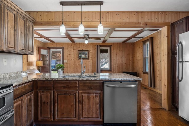 237 Cooper Ln, Smithville, TN 37166 - kitchen with dark wood-style floors, a sink, a ceiling fan, wooden walls, and appliances with stainless steel finishes