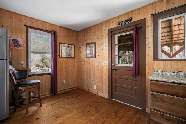 237 Cooper Ln, Smithville, TN 37166 - doorway to outside with wooden walls, baseboards, dark wood-style flooring, and visible vents