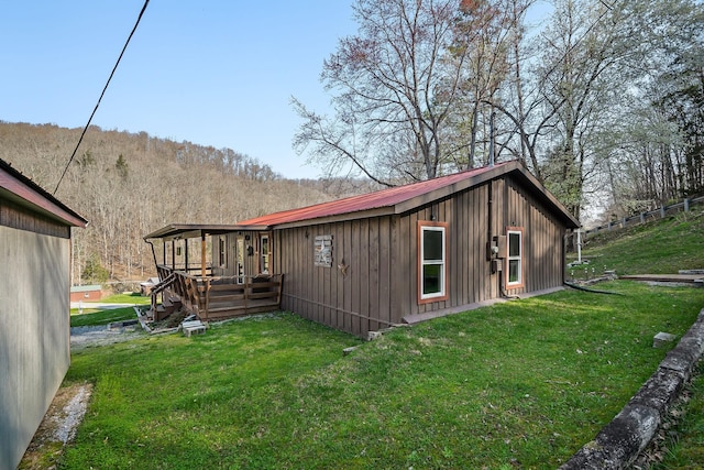 237 Cooper Ln, Smithville, TN 37166 - back of property with board and batten siding, a lawn, metal roof, and a deck