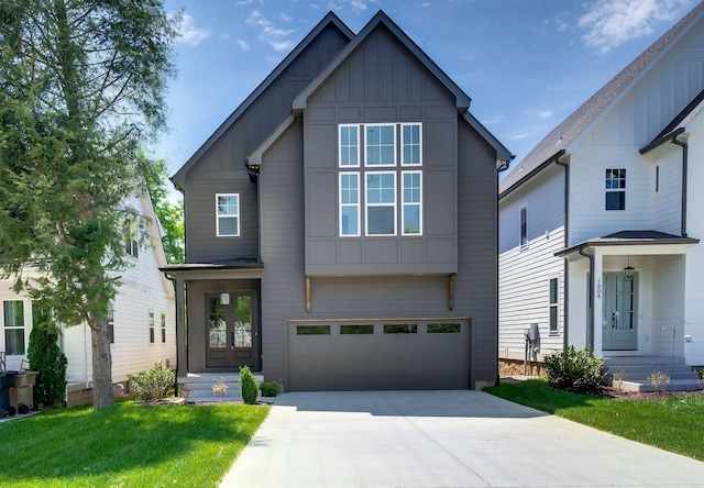 view of front of home with board and batten siding, an attached garage, a front lawn, and concrete driveway
