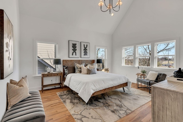 bedroom featuring high vaulted ceiling, light wood finished floors, baseboards, a notable chandelier, and recessed lighting