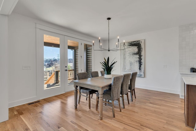dining space with an inviting chandelier, visible vents, french doors, baseboards, and light wood-style flooring