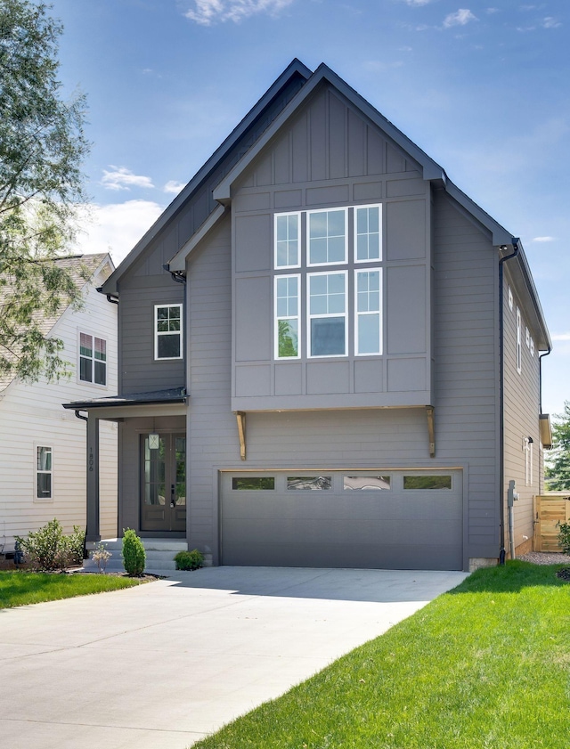 view of front facade featuring board and batten siding, driveway, a front yard, and a garage