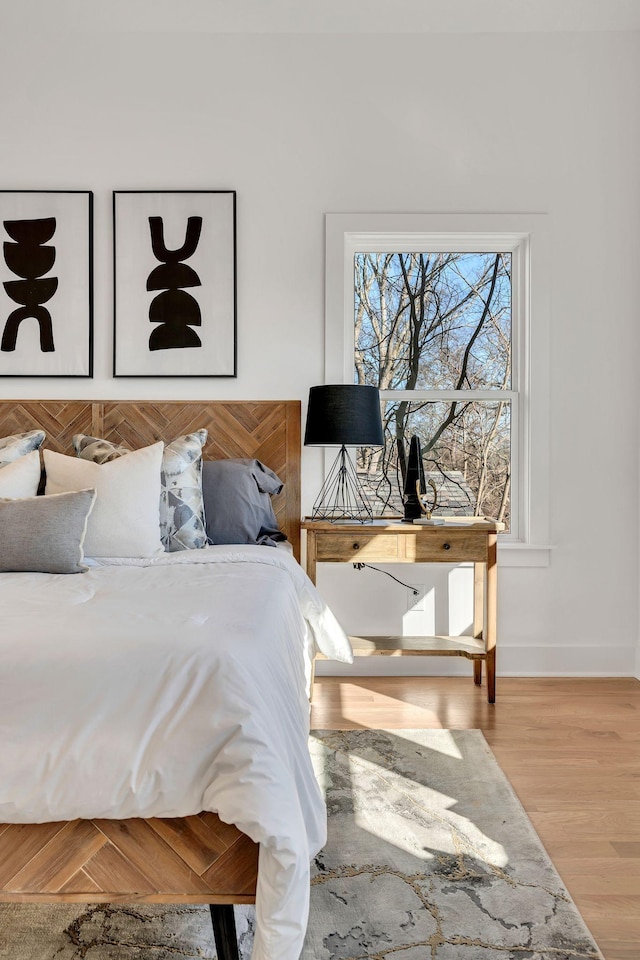bedroom with baseboards and wood finished floors