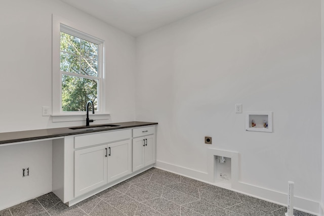 laundry room featuring a sink, baseboards, washer hookup, cabinet space, and electric dryer hookup