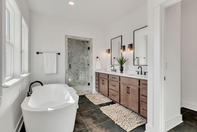 bathroom featuring a freestanding tub, a marble finish shower, a sink, and double vanity