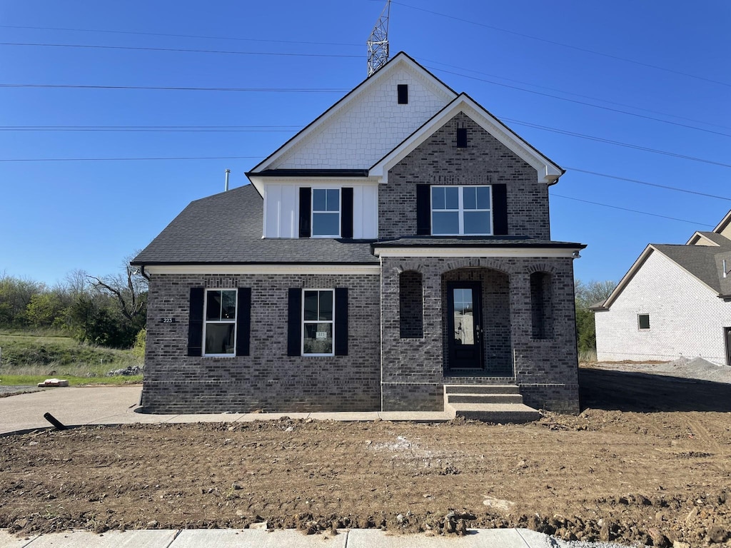 view of front of property featuring brick siding and a porch