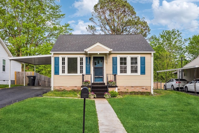 bungalow with fence, a front lawn, driveway, and roof with shingles