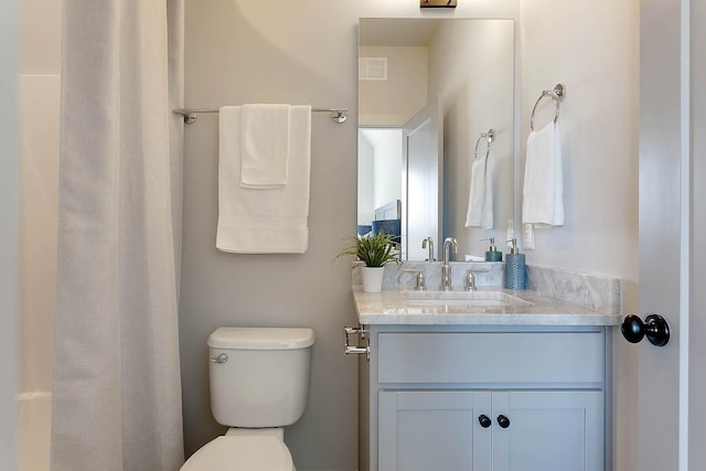 full bathroom featuring toilet, vanity, and visible vents