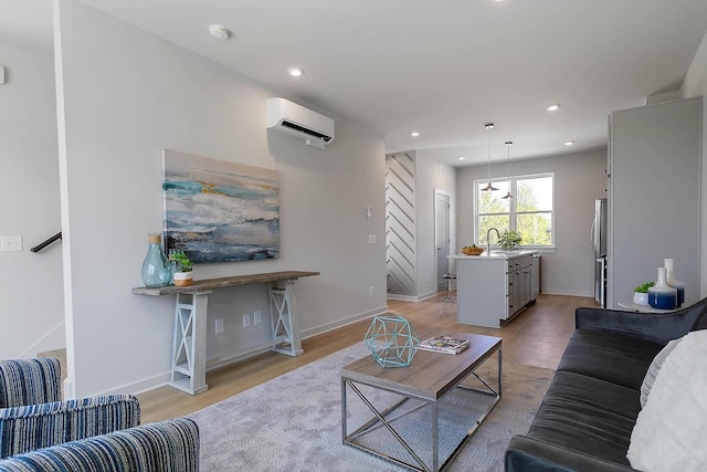 living room featuring light wood-type flooring, recessed lighting, and a wall mounted air conditioner