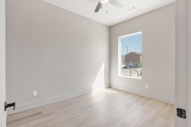 unfurnished room with wood finished floors, a ceiling fan, and baseboards